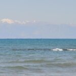 Karlı dağ manzarasında denize girdiler