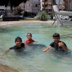 Sıcaktan bunalan çocuklar süs havuzunda serinledi